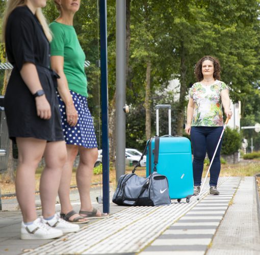 Nursel loopt bij bushalte tegen een koffer